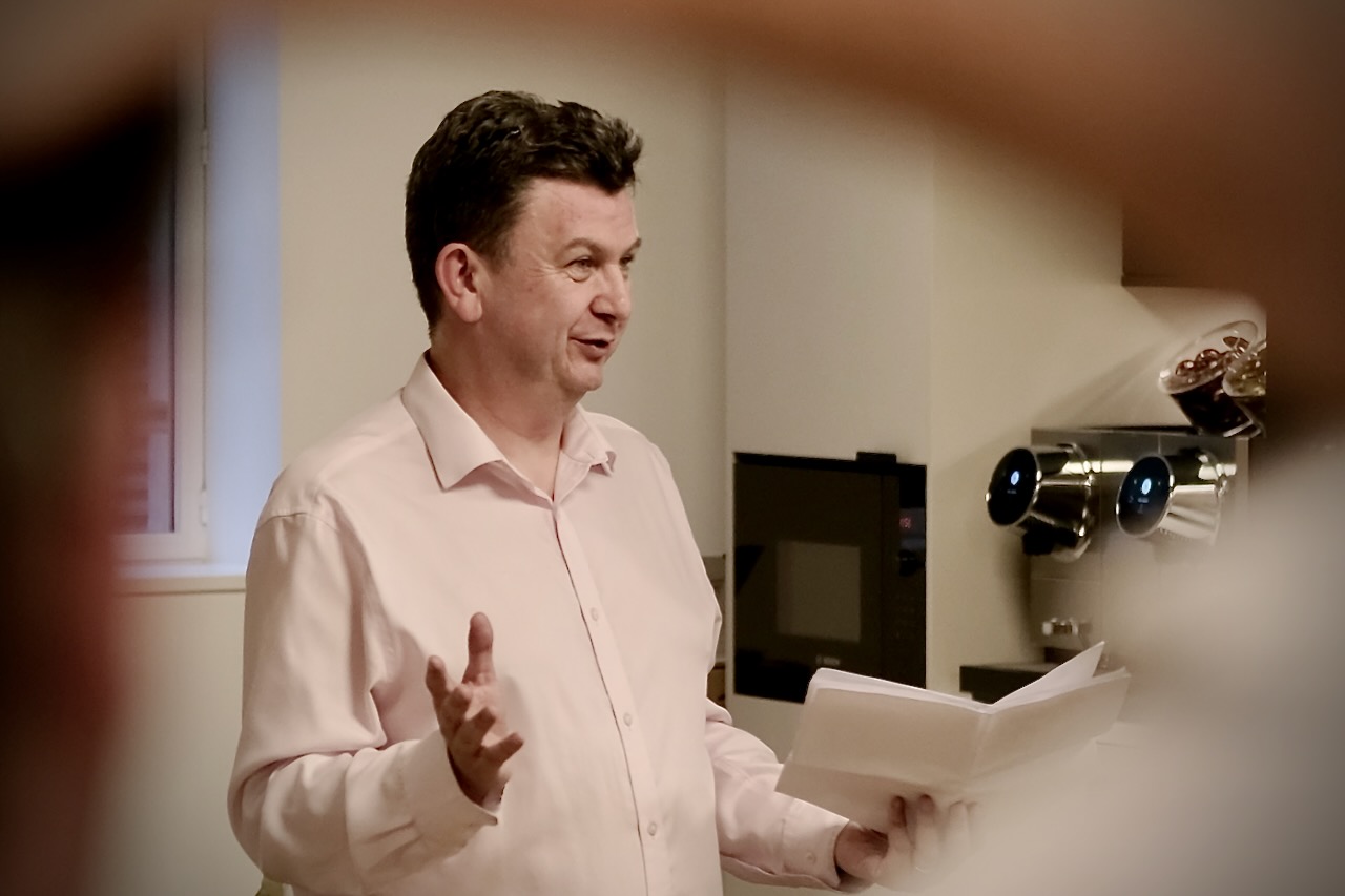 Professor Andy Pardoe delivering a talk on AI in cyber security while gesticulating with his hands